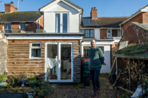 Alastair stands outside his house where he has carried out a number of retrofit energy efficiency upgrades