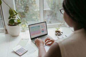 A woman reviewing data on her laptop